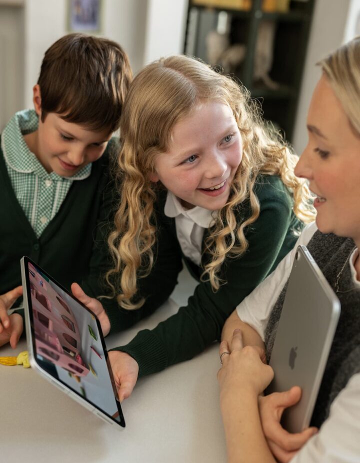 Teacher and students collaborating with a tablet in the classroom.
