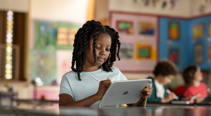 Student using a tablet and stylus for digital learning in the classroom.