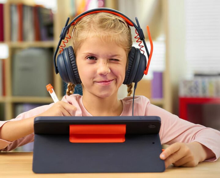 Student using a tablet, stylus, and headset for digital learning.
